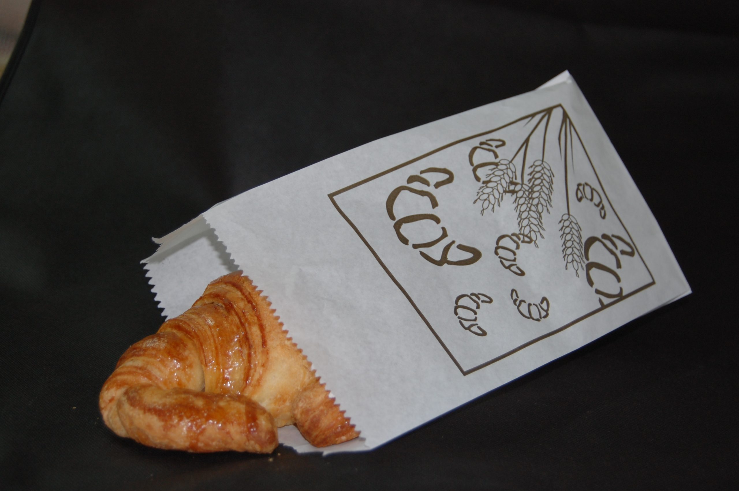 Bolsa de papel para bollería con un croissant